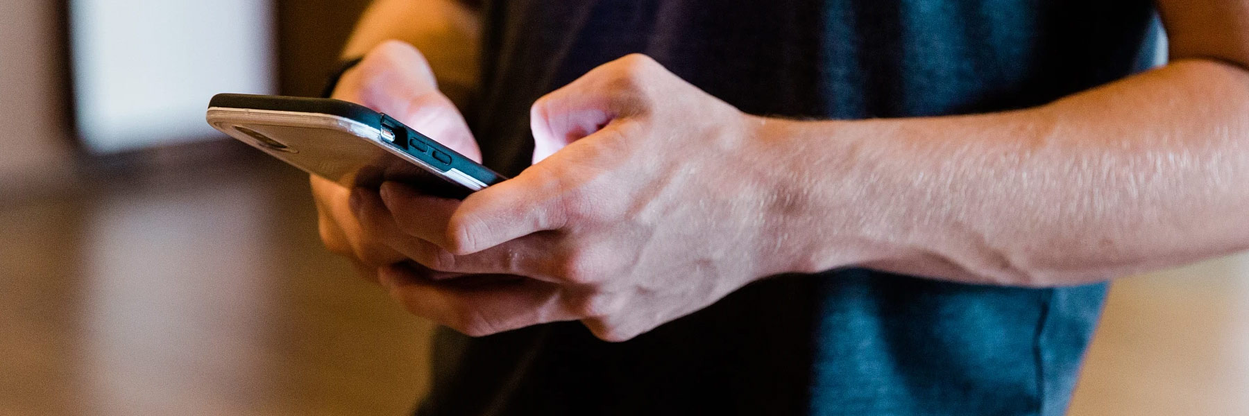 A young man dials numbers on his cellphone.