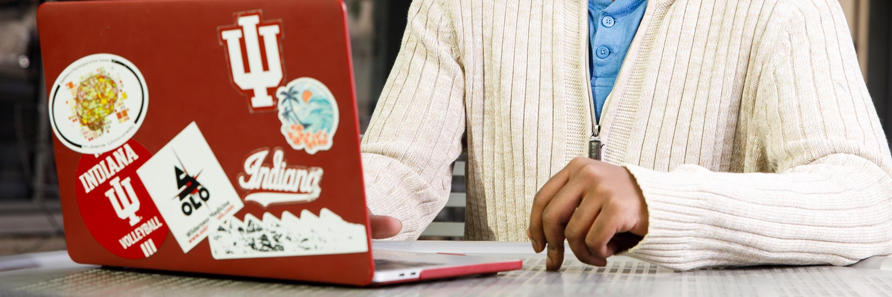 A close-up of a red laptop covered in IU stickers.